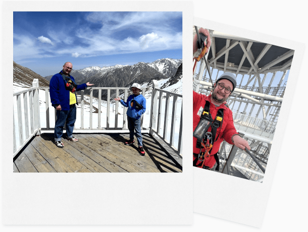 Two polaroids: standing on a viewing platform above snowy mountains, and wearing a climbing harness high inside a steel structure.